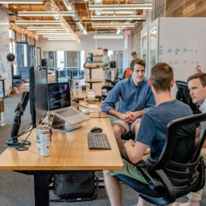 Open-plan office team in conversation — IT Guy Reno